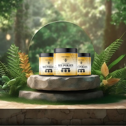 Three jars of organic bee pollen capsules for health displayed on a stone pedestal surrounded by greenery.